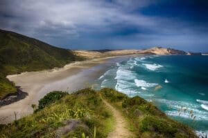 Beachscape. Ocean on the right with a beach and mountains on the left. A photo showing the beauty in the grounding practices in New Zealand.