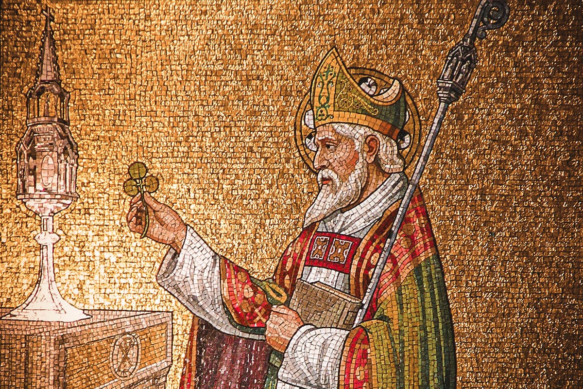 A golden mosaic of St. Patrick holding a clover.