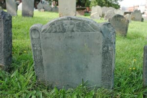 Example of Memento Mori artwork on a gravestone in Old Burying Point Cemetery in Salem Massachusetts, a major site of Dark Tourism