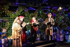 Carolers in 19th century costume. Adventure in travel, legends.