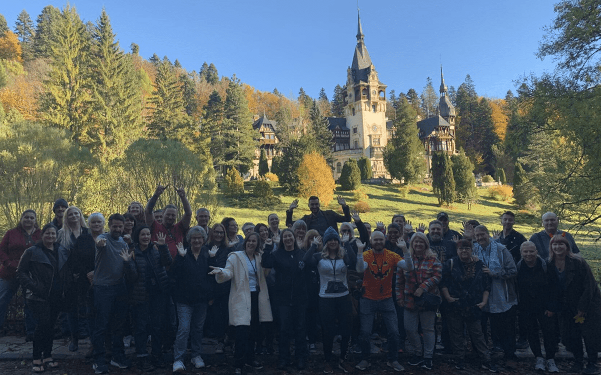 Our travelers in front of the stunning Peles Castle. Transformational Travel, Mysterious Adventures