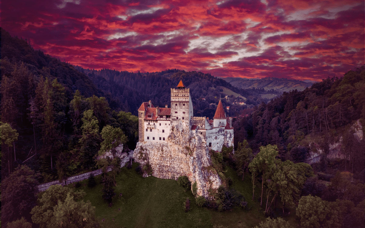 Bran Castle at dusk overlooking misty Transylvanian valley. Legends and Lore, Transformational Travel, Spiritual Journey
