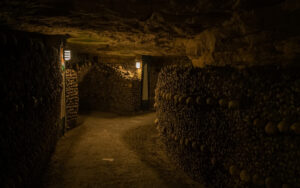 The winding tunnels in the Paris Catacombs are lined with macabre designs arranged from bones. Haunted Catacombs of Paris